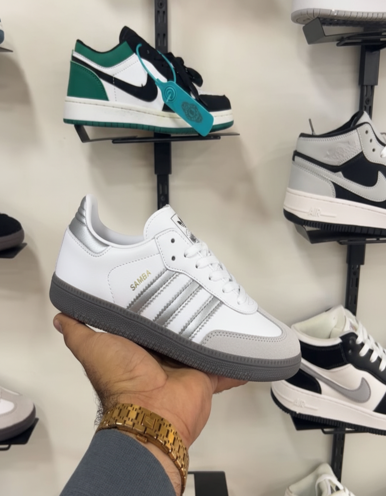 Hand holding Adidas Samba Silver Grey