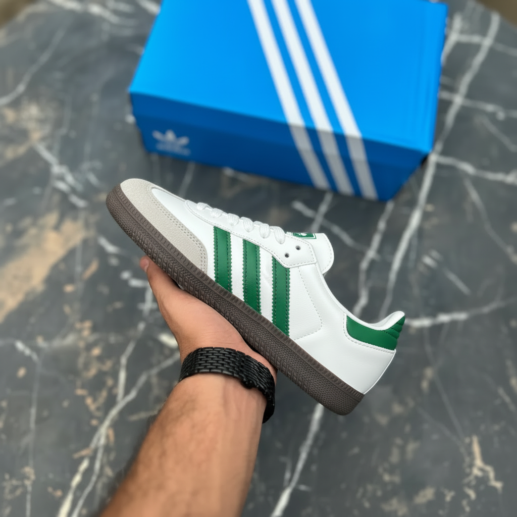 Hand holding Adidas Samba green stripe sneaker