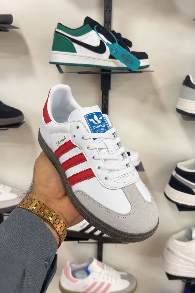 White Red Adidas Samba OG held in hand against shoe store shelf